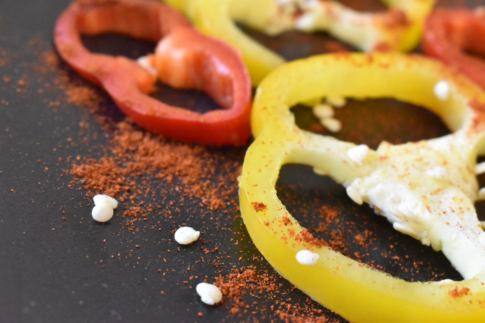 rote und gelbe Paprikascheiben mit rotem Paprikapulver