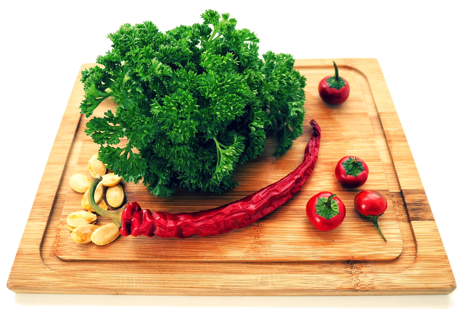 Schneidebrett mit Kräutern und verschiedenen Paprikasorten